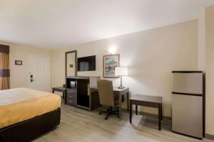 TurnwoldにあるQuality Inn & Suites near Lake Oconeeのベッドとデスクが備わるホテルルームです。