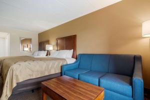オーシャンシティにあるQuality Inn & Suites Oceanblockのホテルルーム(ベッド1台、青いソファ付)