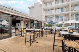 a patio with tables and chairs and a building at Quality Inn & Suites Oceanblock in Ocean City