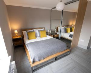 バロックにあるWestertonhill Lodge 3 with Hot Tub Optionのベッドルーム1室(黄色い枕と鏡付きのベッド1台付)