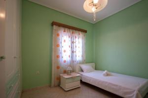 a bedroom with two beds and a window with a chandelier at Majestic view Home just under Meteora Unesco Site in Kalabaka