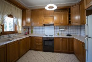 a kitchen with wooden cabinets and a stove top oven at Majestic view Home just under Meteora Unesco Site in Kalabaka