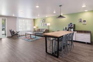 a kitchen and living room with a table and chairs at WoodSpring Suites Concord-Charlotte Speedway in Concord