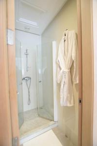 una bata colgada en la puerta de una ducha en el baño en YourPlace - Prestigia - Hay Riad, en Rabat
