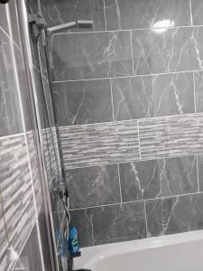 a bathroom with a shower with a marble wall at Beautiful and modern House in Gravesend in Gravesend