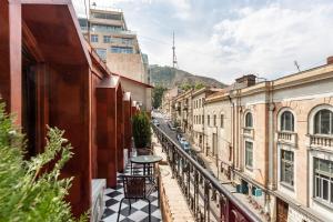 een balkon met een tafel in een stadsstraat bij Shota Rustaveli Aparthotel in Tbilisi City