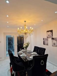 uma sala de jantar com uma mesa e cadeiras e um lustre em Beautiful and modern House in Gravesend em Gravesend