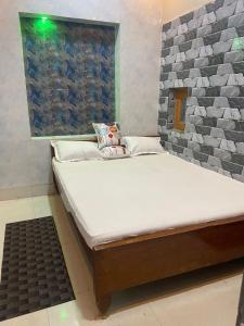 uma pequena cama num quarto com uma janela em Suraj Bhawan em Gaya