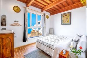 una camera con un letto e una grande finestra di Riad Kafila a Essaouira