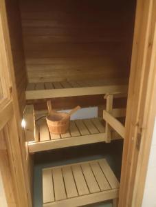 une armoire en bois avec un bol sur l'étagère du bas dans l'établissement FREE Sauna and Laundry, 5min to Metro, 15min to Center, à Espoo