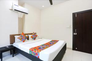 a bedroom with a bed with a colorful blanket on it at FabHotel Destiny 74 in Indore