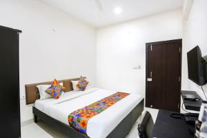 a bedroom with a bed and a desk with a computer at FabHotel Destiny 74 in Indore