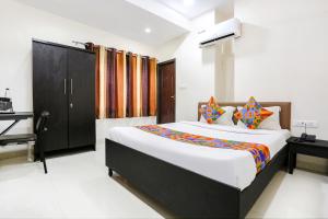 a bedroom with a large bed and a piano at FabHotel Destiny 74 in Indore