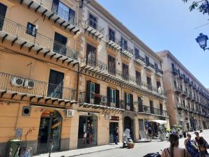 - un bâtiment avec balcon sur le côté d'une rue dans l'établissement Cinematocasa Suite, à Palerme