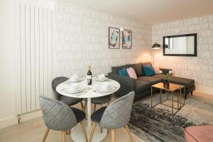 a living room with a table and a couch at Fitzrovia - Charlotte Street by Viridian Apartments in London