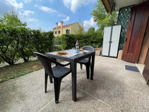 - une table noire avec 2 chaises et une bouteille de vin dans l'établissement ONLY THE BEST 5 La tua Suite tra Venezia e Treviso, à San Trovaso