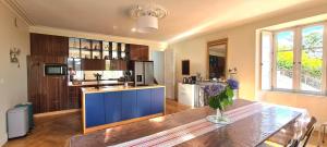 uma cozinha com uma mesa e uma ilha azul em Les Hauts de St Jacques maison d'exception 300m2, jardin arboré 2000m2 em Pouzauges