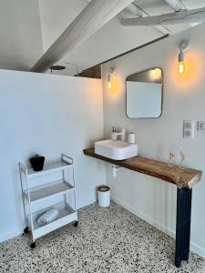 uma casa de banho com um lavatório e um espelho em La Villa 1777 em Lagnes
