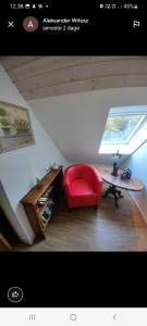 un soggiorno con tavolo e sedia rossa di The parrot hotel, live in a rescue animal park a Næstved