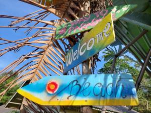 a sign for a beach bar on a pole at Papaya Cottage Koh Chang in Ko Chang