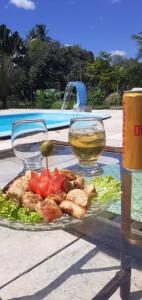 a plate of food on a table next to a pool at Pousada Chiveve in Cumbuco