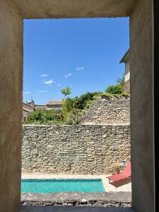 Lagnes的住宿－La Villa 1777，享有石墙和游泳池的景色