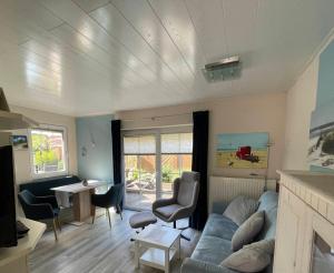 ein Wohnzimmer mit einem blauen Sofa und einem Tisch in der Unterkunft Ferienhaus am Südstrand Borkum in Borkum