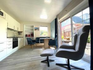 uma cozinha e sala de estar com cadeiras e uma mesa em Ferienhaus am Südstrand Borkum em Borkum