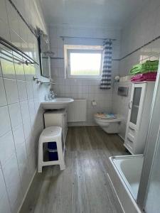 ein kleines Badezimmer mit Waschbecken und Toilette in der Unterkunft Ferienhaus am Südstrand Borkum in Borkum + 27 Fotos