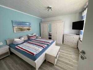 ein Schlafzimmer mit einem Bett und einem TV in der Unterkunft Ferienhaus am Südstrand Borkum in Borkum