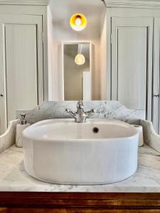 Baño blanco con lavabo y espejo en La Villa 1777, en Lagnes