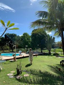 a man walking in the grass near a swimming pool at Pousada Chiveve in Cumbuco