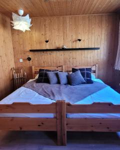 een slaapkamer met een groot bed in een houten muur bij Magical Hideaway in Leysin