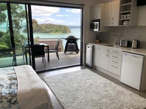 a kitchen with a view of a patio with a grill at Bayview Corner Suite Unit 2 - Paihia Unit in Paihia