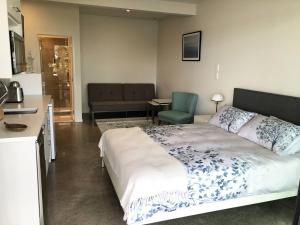 a bedroom with a bed and a table and a kitchen at Bayview Corner Suite Unit 2 - Paihia Unit in Paihia