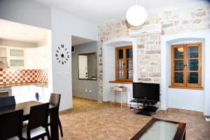 a kitchen and dining room with a table and a tv at Cozy 2 Bedroom Apartment in Antique Bizanti Palace in Kotor
