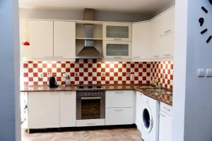 a kitchen with white cabinets and a checkered wall at Cozy 2 Bedroom Apartment in Antique Bizanti Palace in Kotor