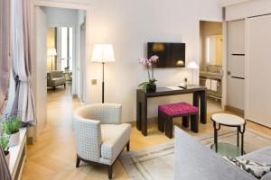 uma sala de estar com uma secretária e cadeiras num quarto em Hôtel Bedford em Paris