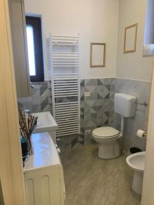 bagno con servizi igienici bianchi e lavandino di Casa Gialla 89 a Garbagnate Milanese