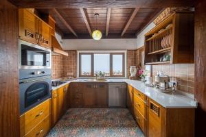 una cocina con armarios de madera y una gran ventana en Villa Alisios La Asomada, en Tías