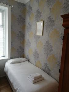 1 dormitorio con 1 cama con 2 toallas en Portum -John St Apartment, en Helensburgh