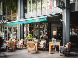 un ristorante con tavoli e sedie di fronte a un edificio di AMERON Luzern Hotel Flora a Lucerna