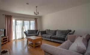 a living room with two couches and a table at Botany Bay Holiday House - Family friendly, 50M from the beach in Kent