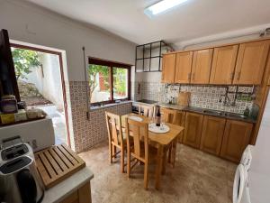 eine Küche mit einem Tisch und Stühlen im Zimmer in der Unterkunft Moradia com Alma Xico's House in Coimbra