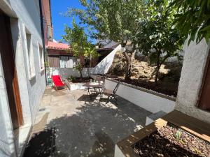 a patio with chairs and a table and a tree at Moradia com Alma Xico's House in Coimbra
