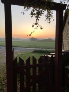 a view from the porch of a farm house at sunset at Nordgården - ferie på landet in Skibby