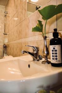a bathroom sink with a bottle of wine on it at Villa Sol Bed & Breakfast in Borgholm