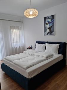 um quarto com uma cama grande e uma cabeceira azul em Sasu Apartment em Timisoara