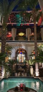 een hotellobby met een zwembad en palmbomen bij Riad Monceau in Marrakesh
