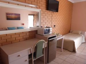 Zimmer mit einem Bett und einer Küche mit einer Mikrowelle in der Unterkunft Fullarton Motor Lodge in Adelaide